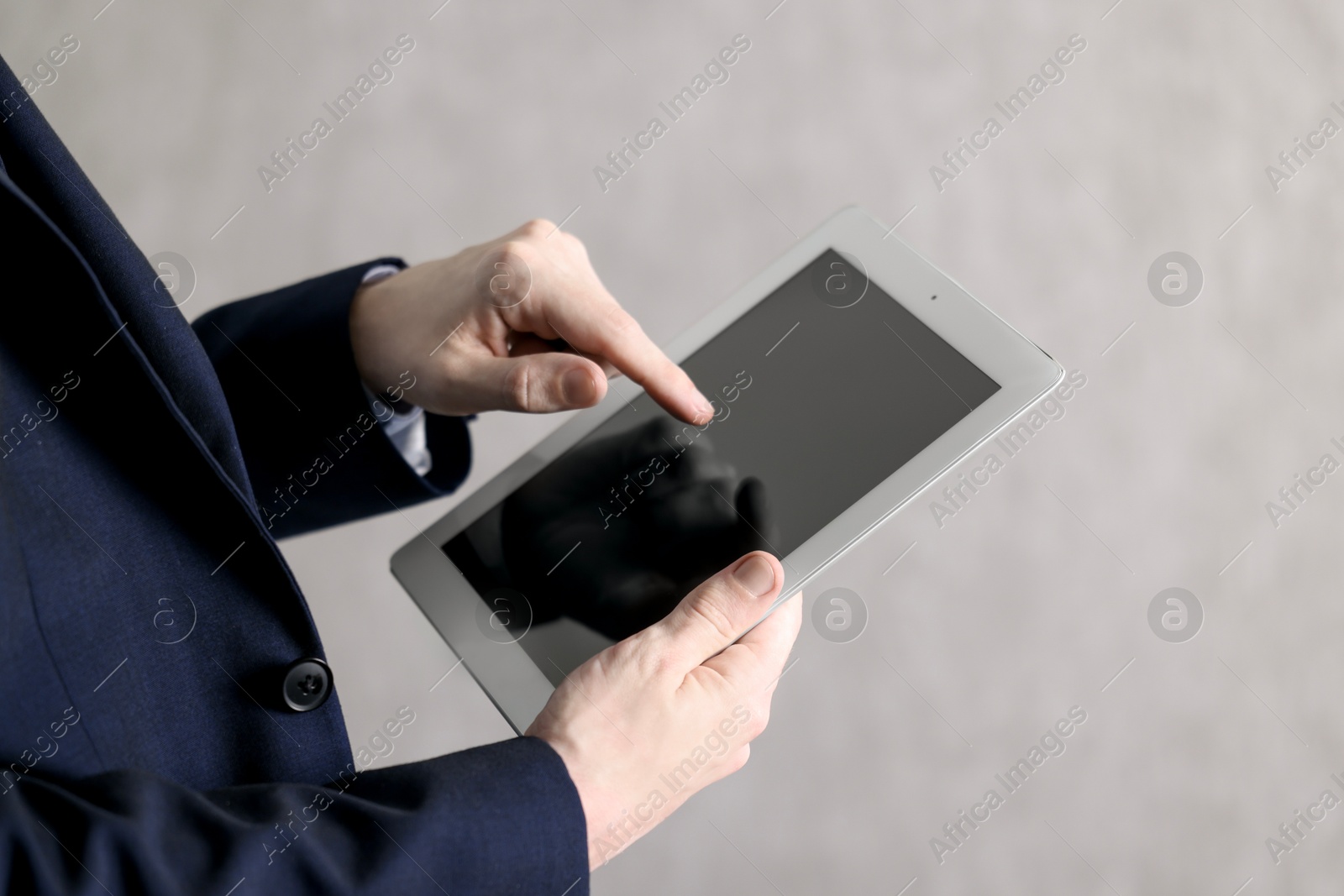 Photo of Businessman using tablet indoors, closeup. Modern technology