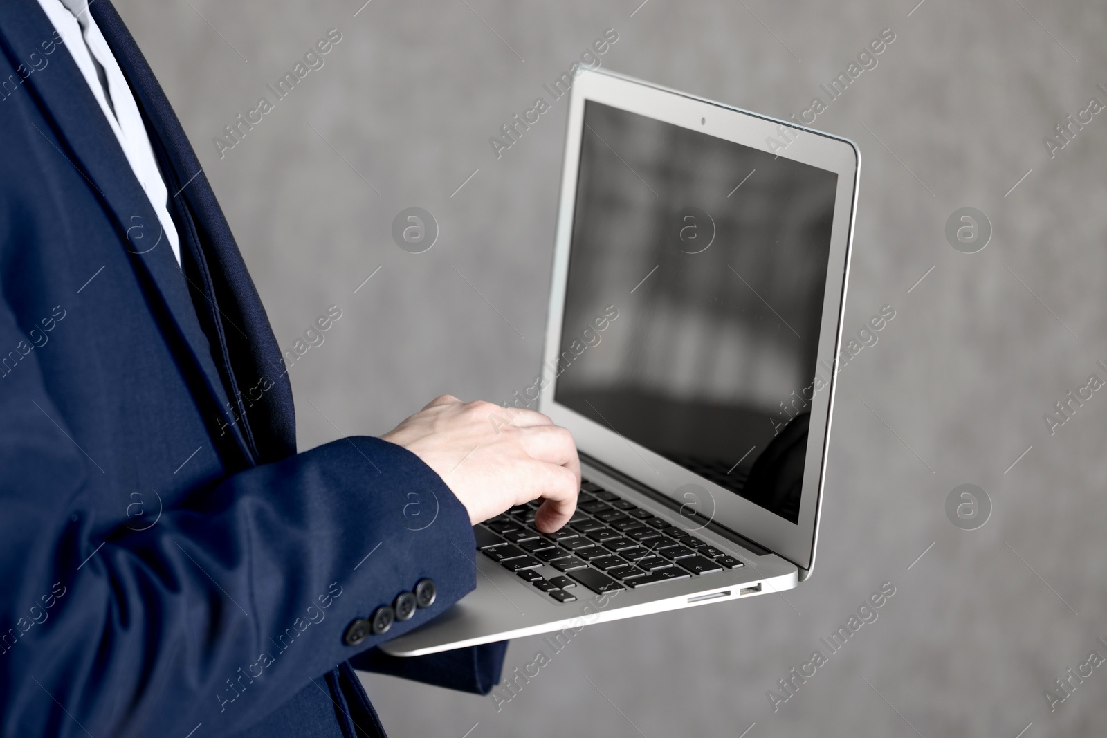 Photo of Businessman using laptop indoors, closeup. Modern technology