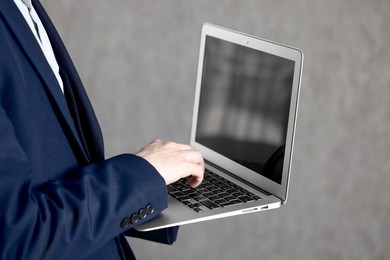 Photo of Businessman using laptop indoors, closeup. Modern technology