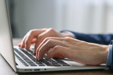 Photo of Businessman using laptop indoors, closeup. Modern technology