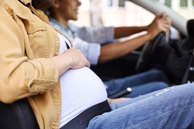 Photo of Pregnant woman travelling with her husband by car, closeup