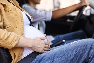 Photo of Pregnant woman travelling with her husband by car, closeup