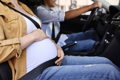 Photo of Pregnant woman travelling with her husband by car, closeup