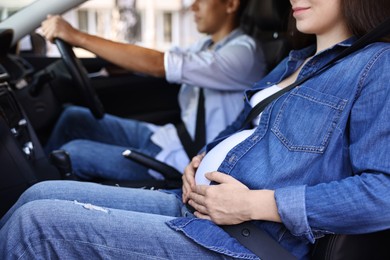 Photo of Pregnant woman travelling with her husband by car, closeup