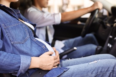 Photo of Pregnant woman travelling with her husband by car, closeup