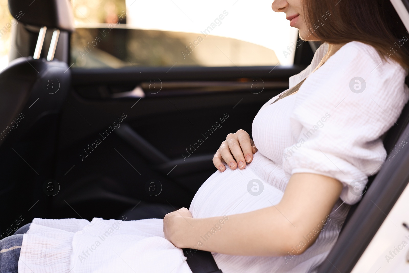 Photo of Pregnant woman with safety belt in car, closeup