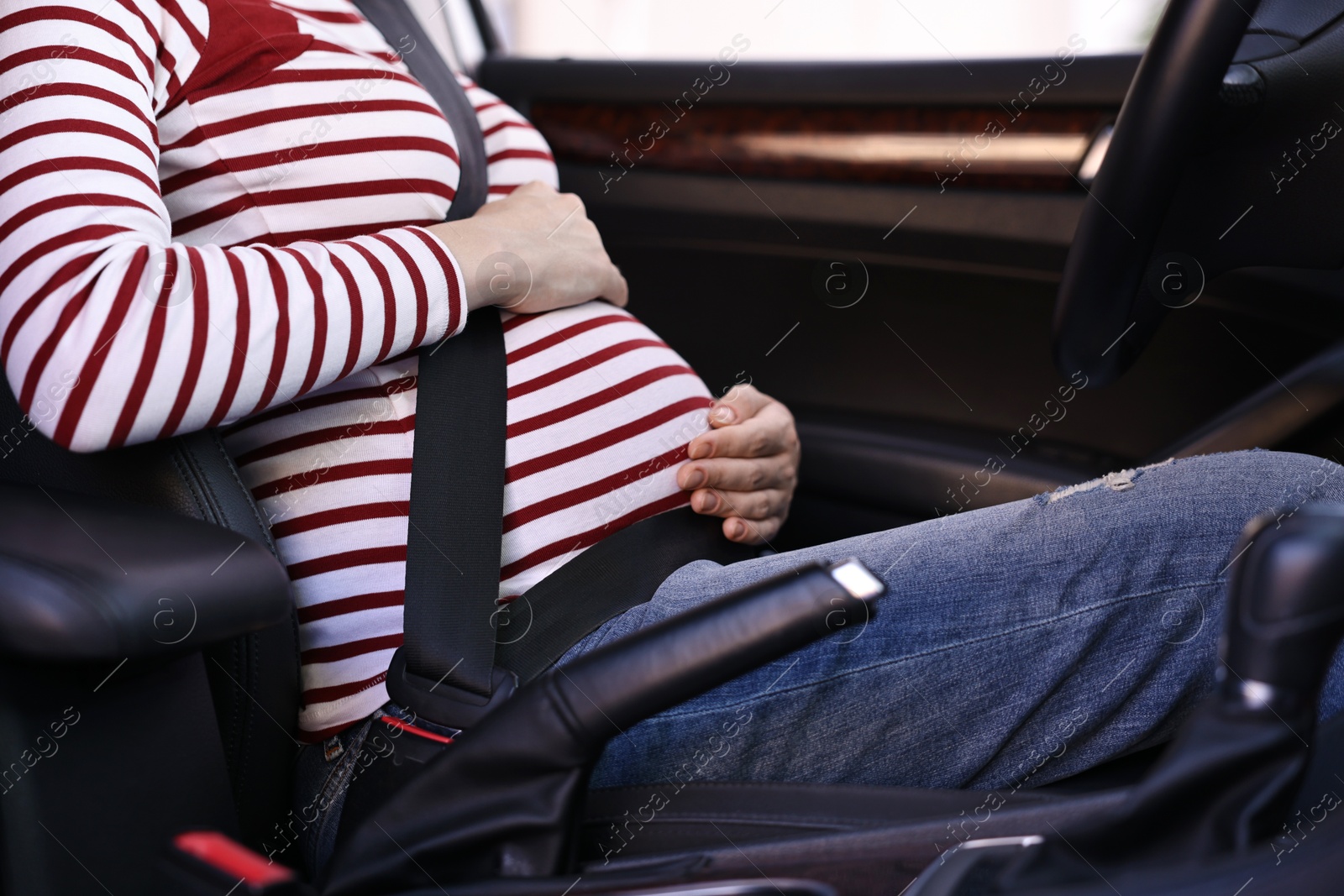 Photo of Pregnant woman with safety belt in car, closeup