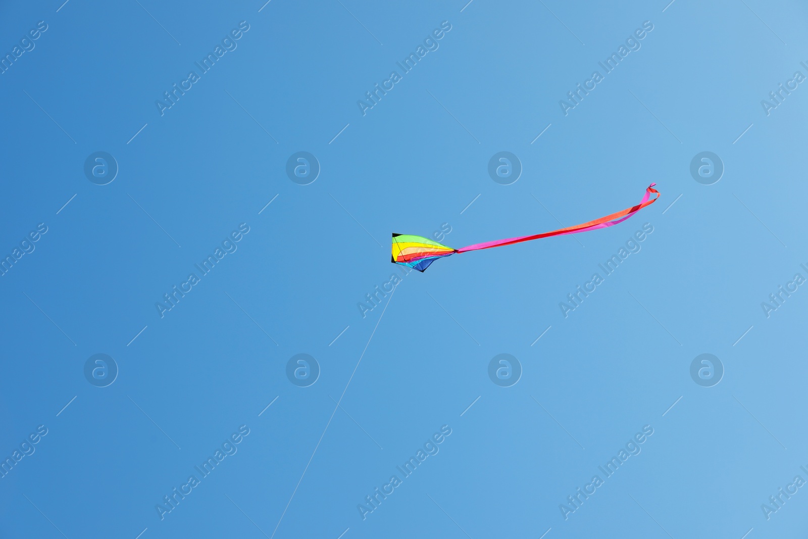 One colorful kite flying in blue sky Photo of One colorful kite flying in blue sky