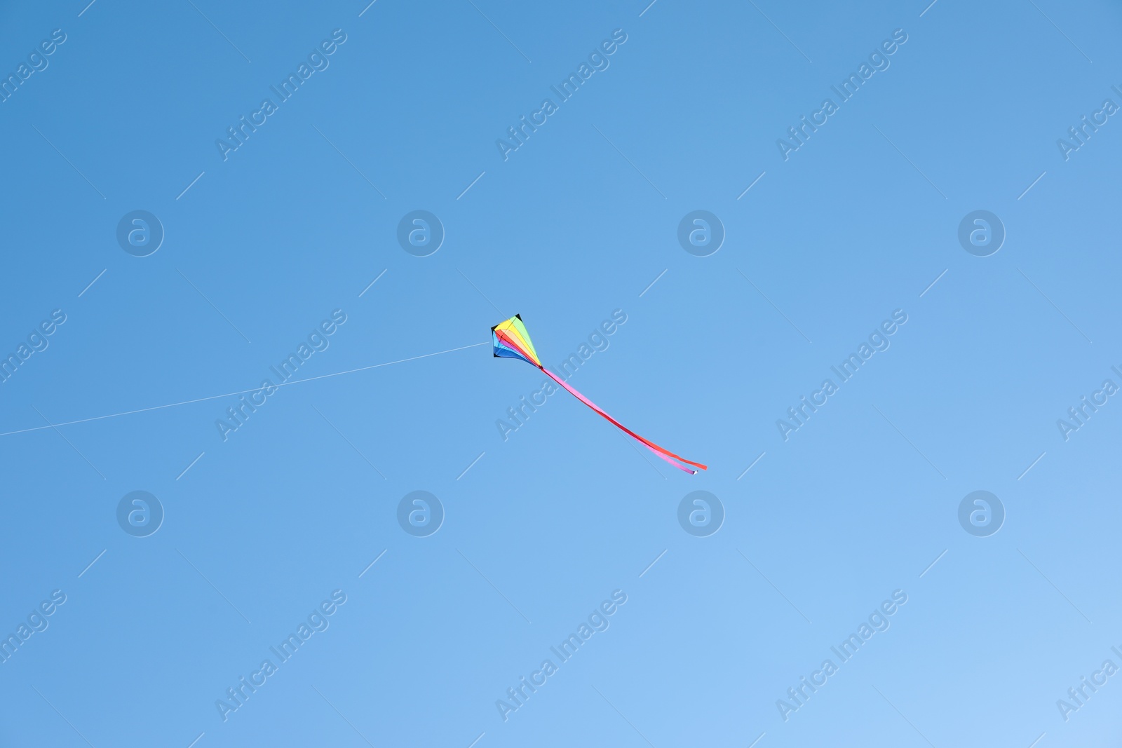 One colorful kite flying in blue sky Photo of One colorful kite flying in blue sky