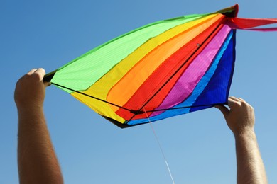Photo of Man with kite against blue sky, closeup