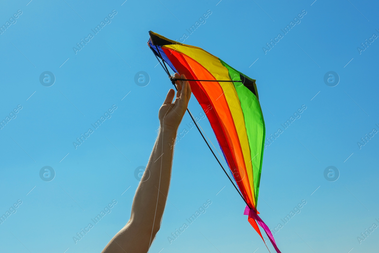 Man with kite against blue sky, closeup Photo of Man with kite against blue sky, closeup