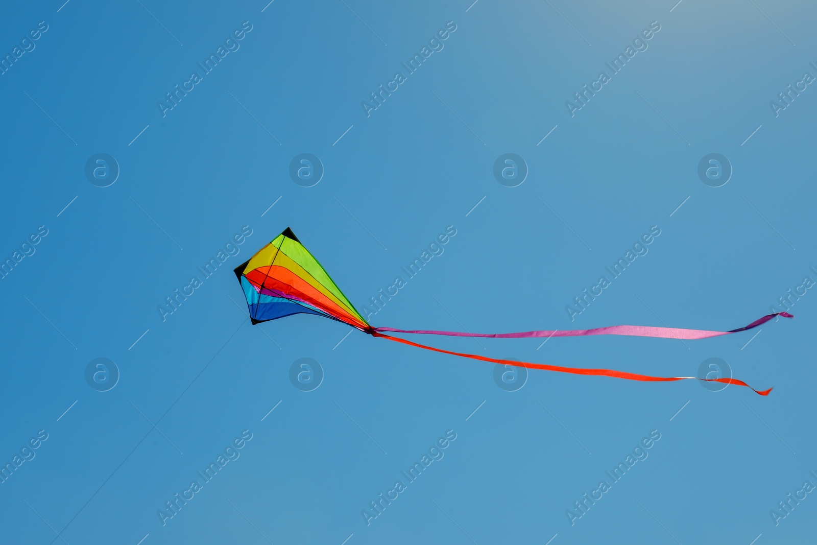 One colorful kite flying in blue sky Photo of One colorful kite flying in blue sky