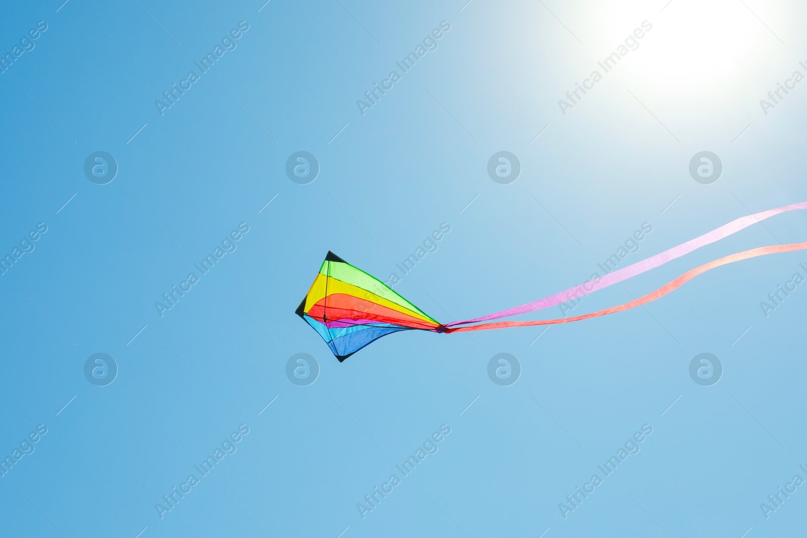 One colorful kite flying in blue sky Photo of One colorful kite flying in blue sky