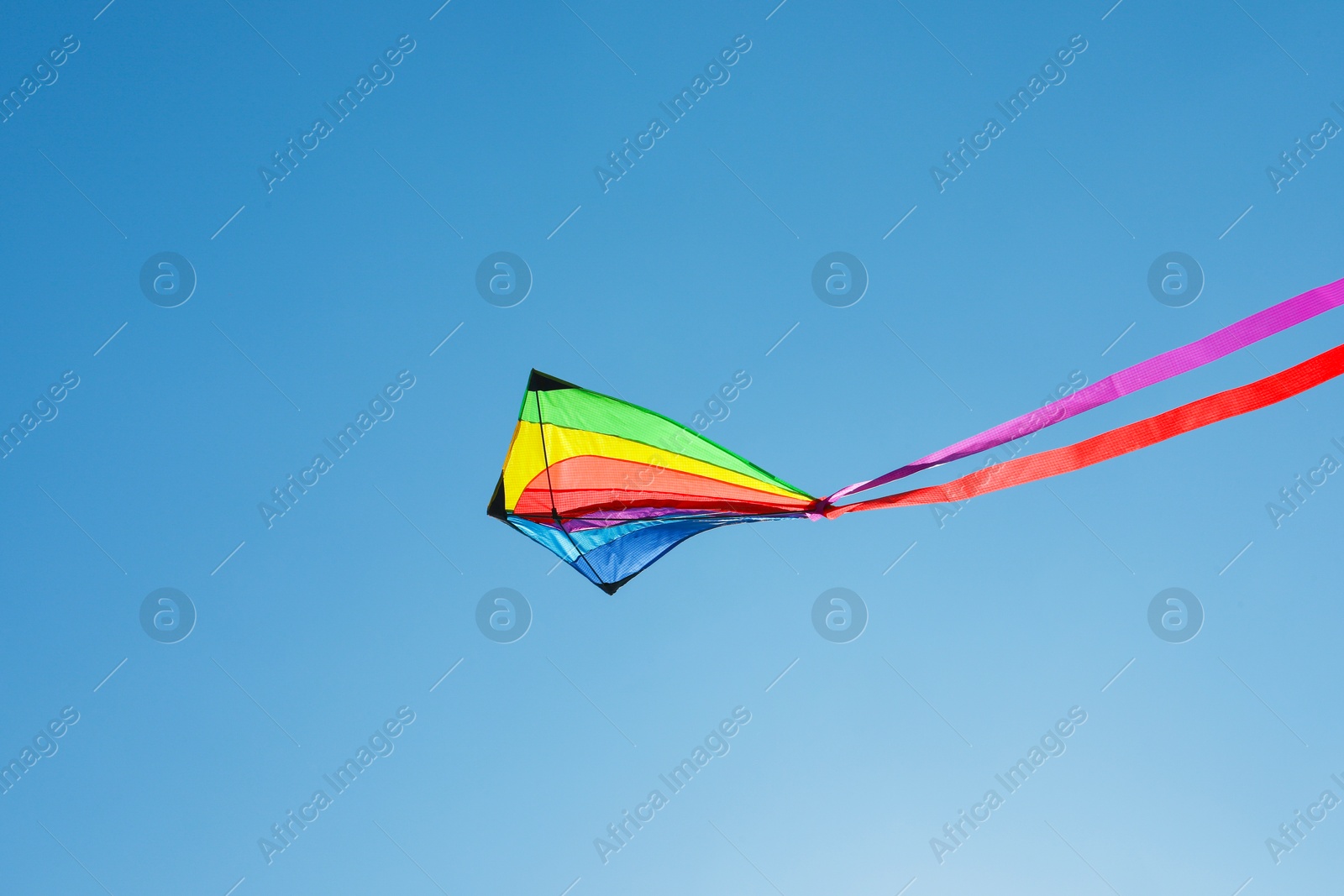 One colorful kite flying in blue sky Photo of One colorful kite flying in blue sky