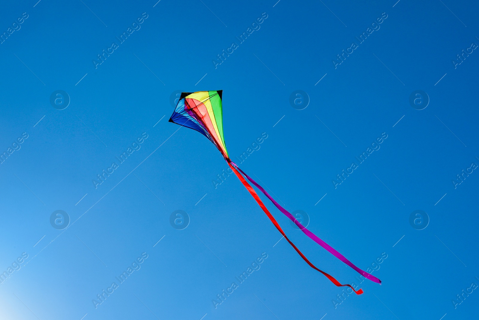One colorful kite flying in blue sky Photo of One colorful kite flying in blue sky