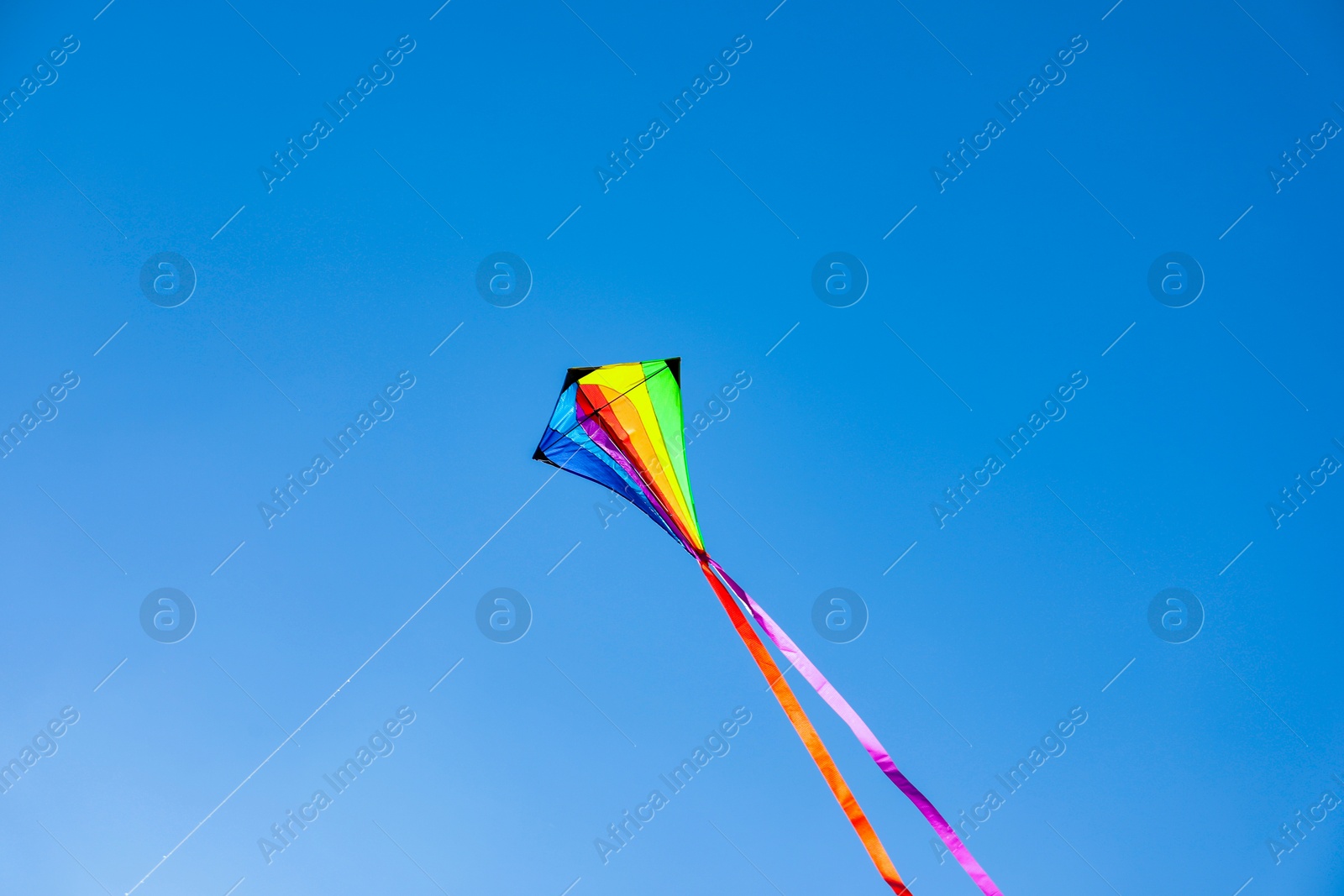 One colorful kite flying in blue sky Photo of One colorful kite flying in blue sky