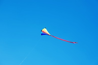 Photo of One colorful kite flying in blue sky