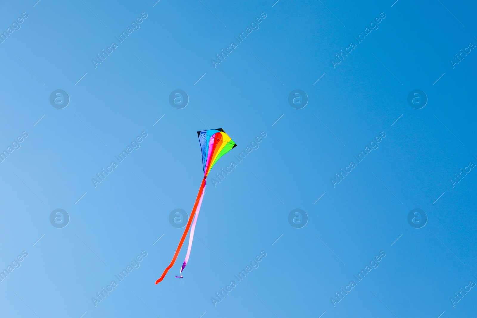One colorful kite flying in blue sky Photo of One colorful kite flying in blue sky