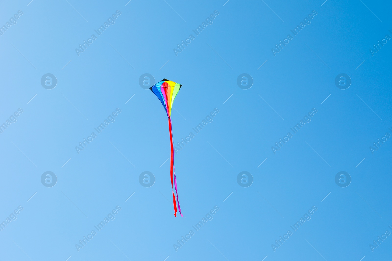 One colorful kite flying in blue sky Photo of One colorful kite flying in blue sky