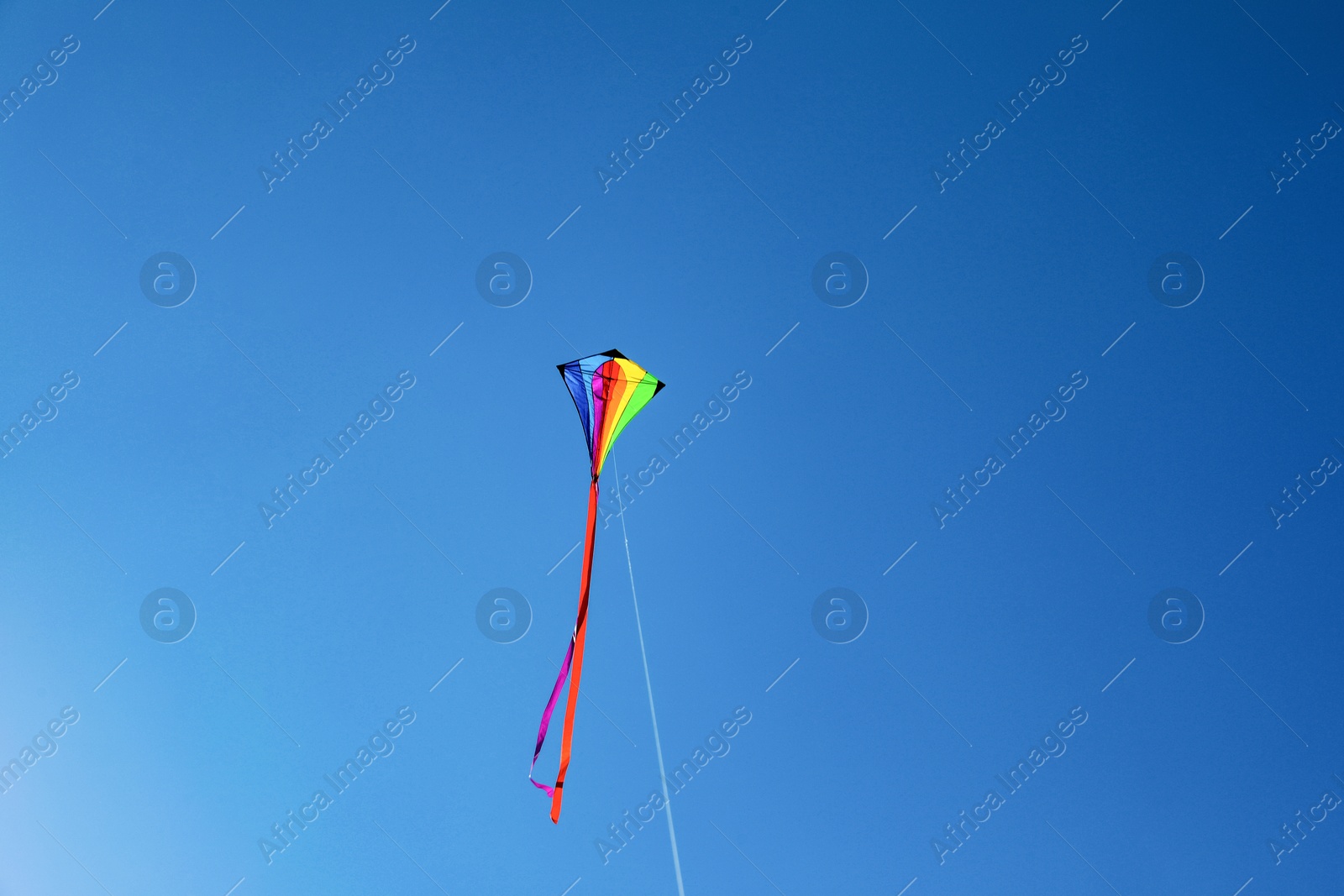 One colorful kite flying in blue sky Photo of One colorful kite flying in blue sky