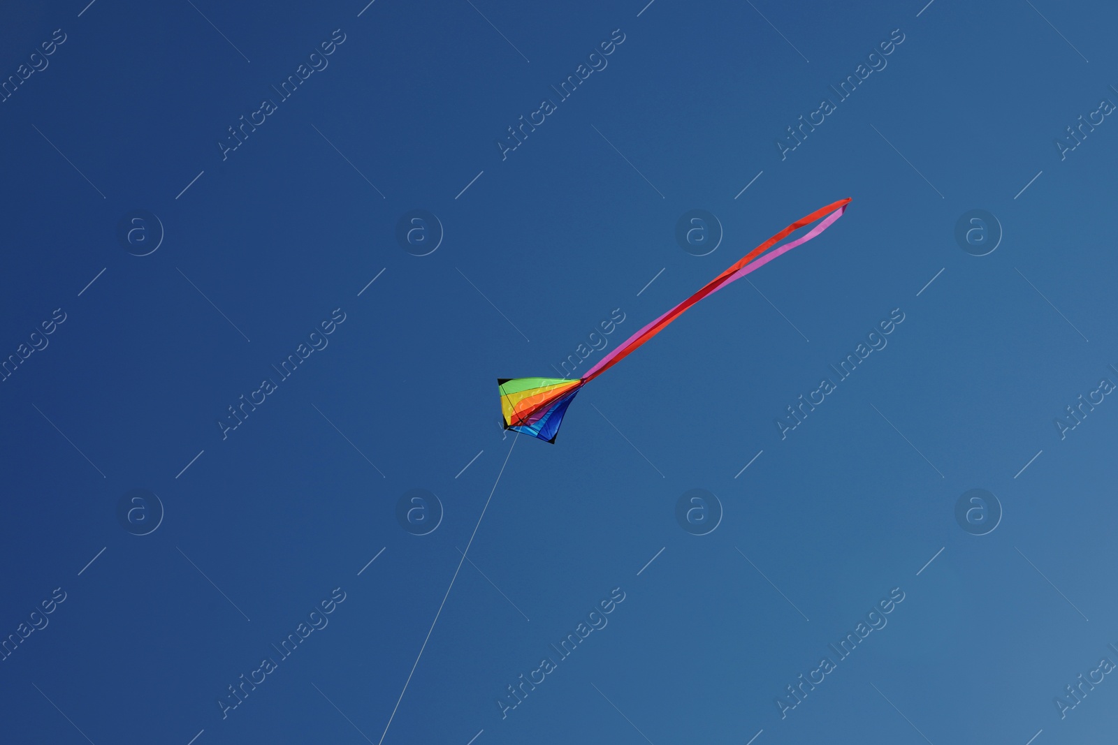 One colorful kite flying in blue sky Photo of One colorful kite flying in blue sky