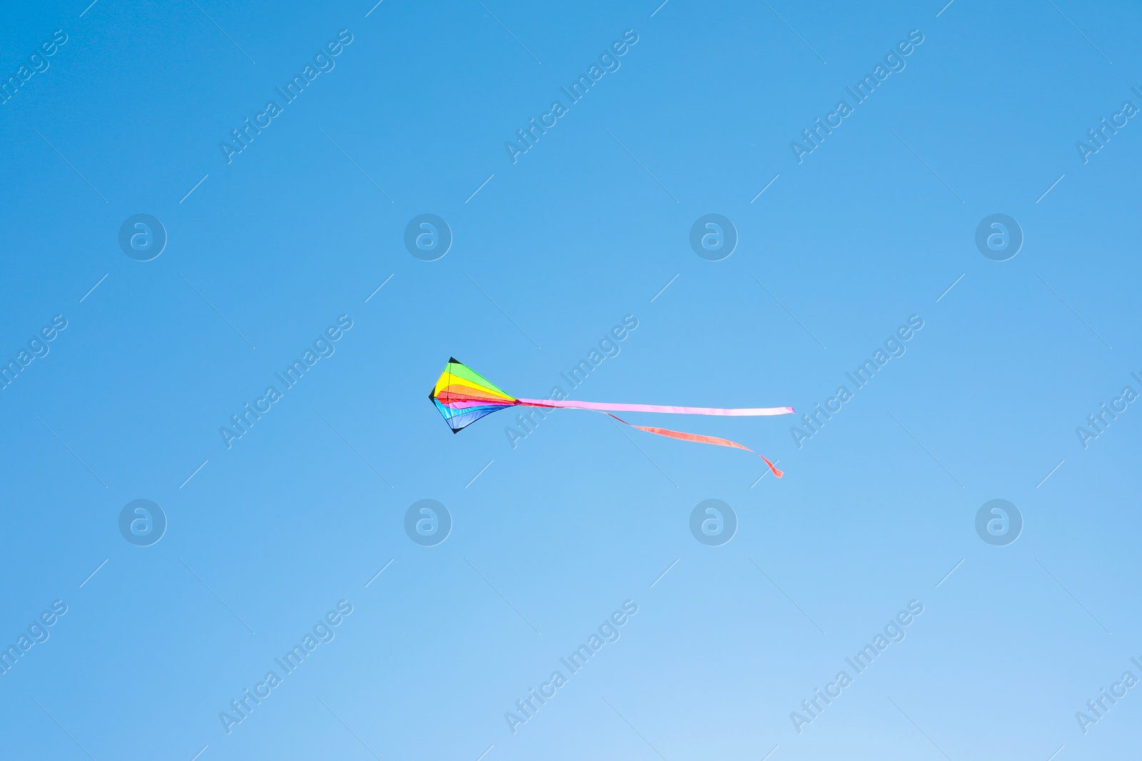 One colorful kite flying in blue sky Photo of One colorful kite flying in blue sky