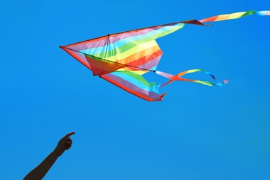 Photo of Woman with colorful kite against blue sky, closeup