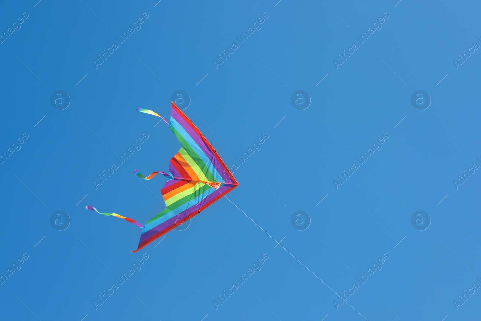 One colorful kite flying in blue sky Photo of One colorful kite flying in blue sky
