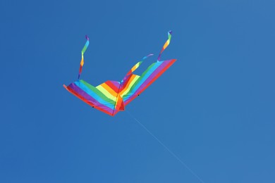 Photo of One colorful kite flying in blue sky