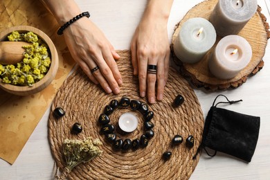 Photo of Woman with black runes at wooden table, top view