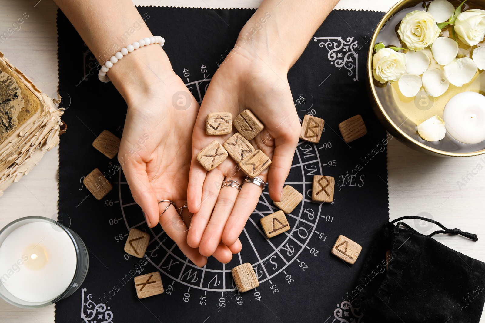 Photo of Woman with wooden runes at table, top view