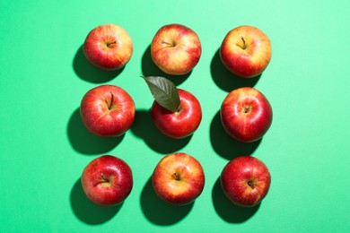 Photo of Red apples and seeds on green background, flat lay