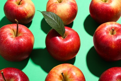 Photo of Fresh red apples on green background, closeup