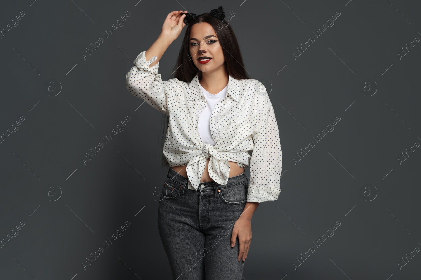 Photo of Attractive woman with cat makeup and ears on grey background