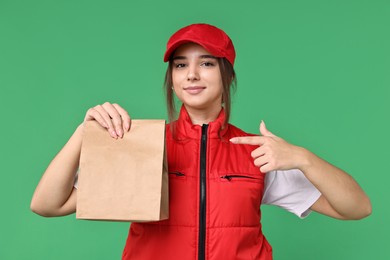 Photo of Girl in uniform with paper bag on green background. Work for teenagers