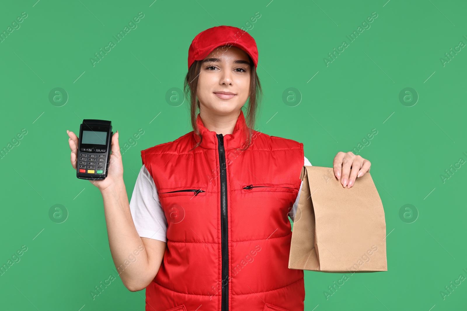 Photo of Girl in uniform with paper bag and payment terminal on green background. Work for teenagers