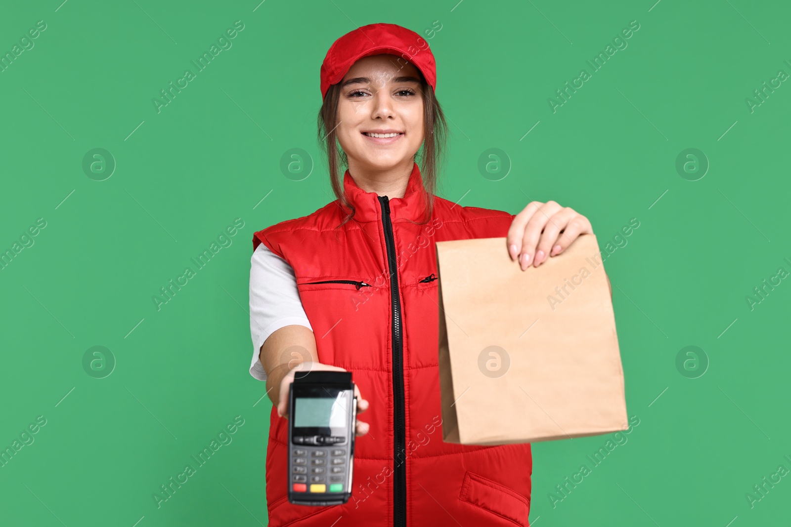 Photo of Girl in uniform with paper bag and payment terminal on green background. Work for teenagers