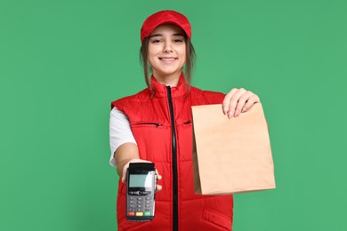 Photo of Girl in uniform with paper bag and payment terminal on green background. Work for teenagers