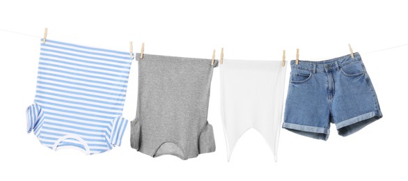 Different clothes drying on laundry line against white background