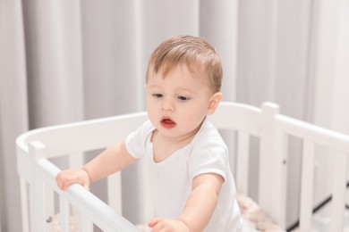 Photo of Cute little baby in crib at home