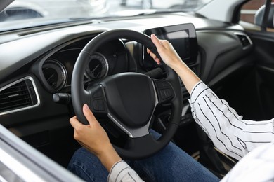 Photo of Young woman inside new car in salon, closeup