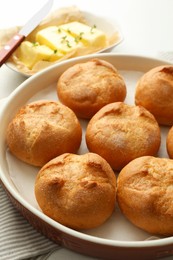 Photo of Baking dish with homemade tasty buns on table, closeup