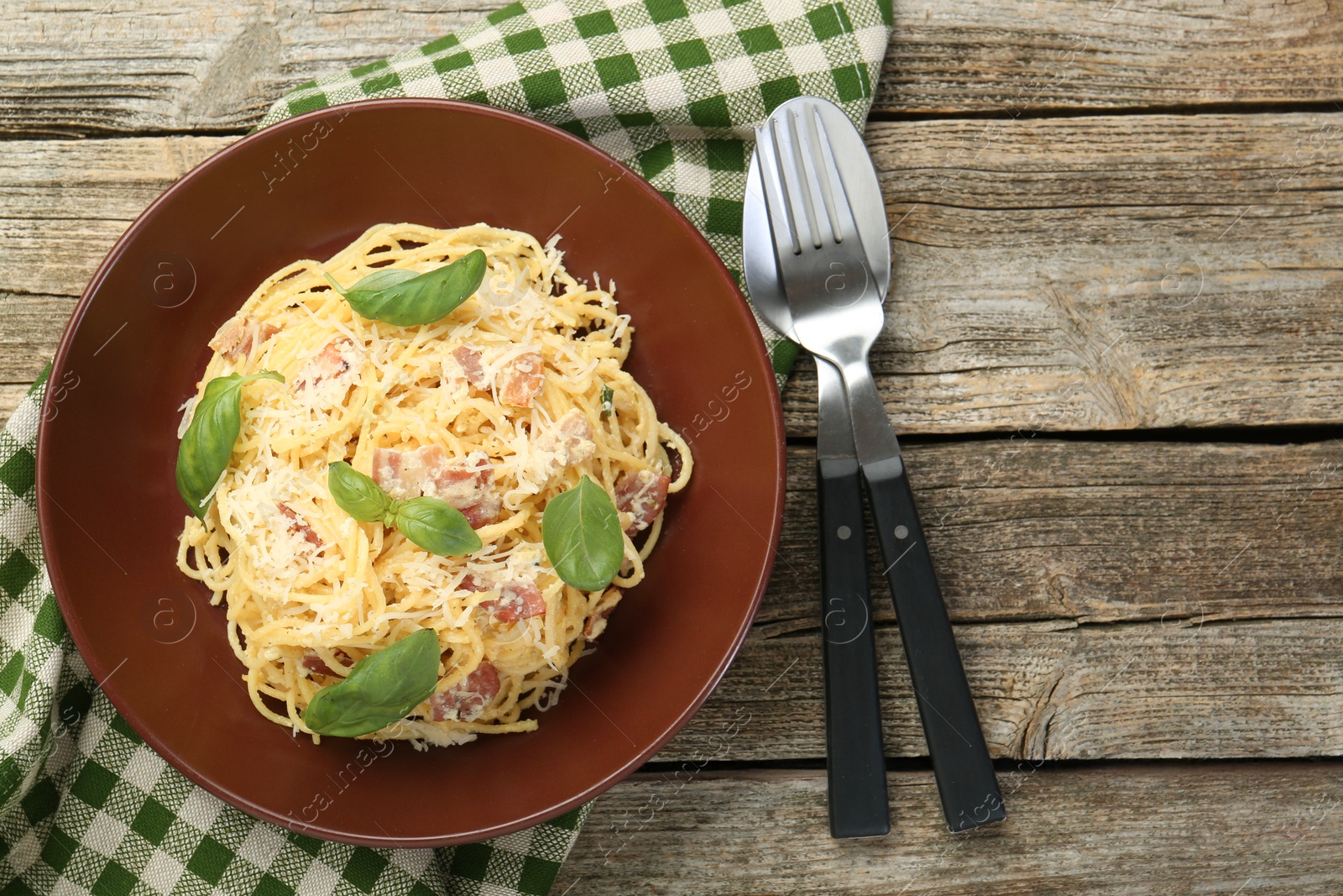 Photo of Delicious pasta Carbonara served on wooden table, flat lay