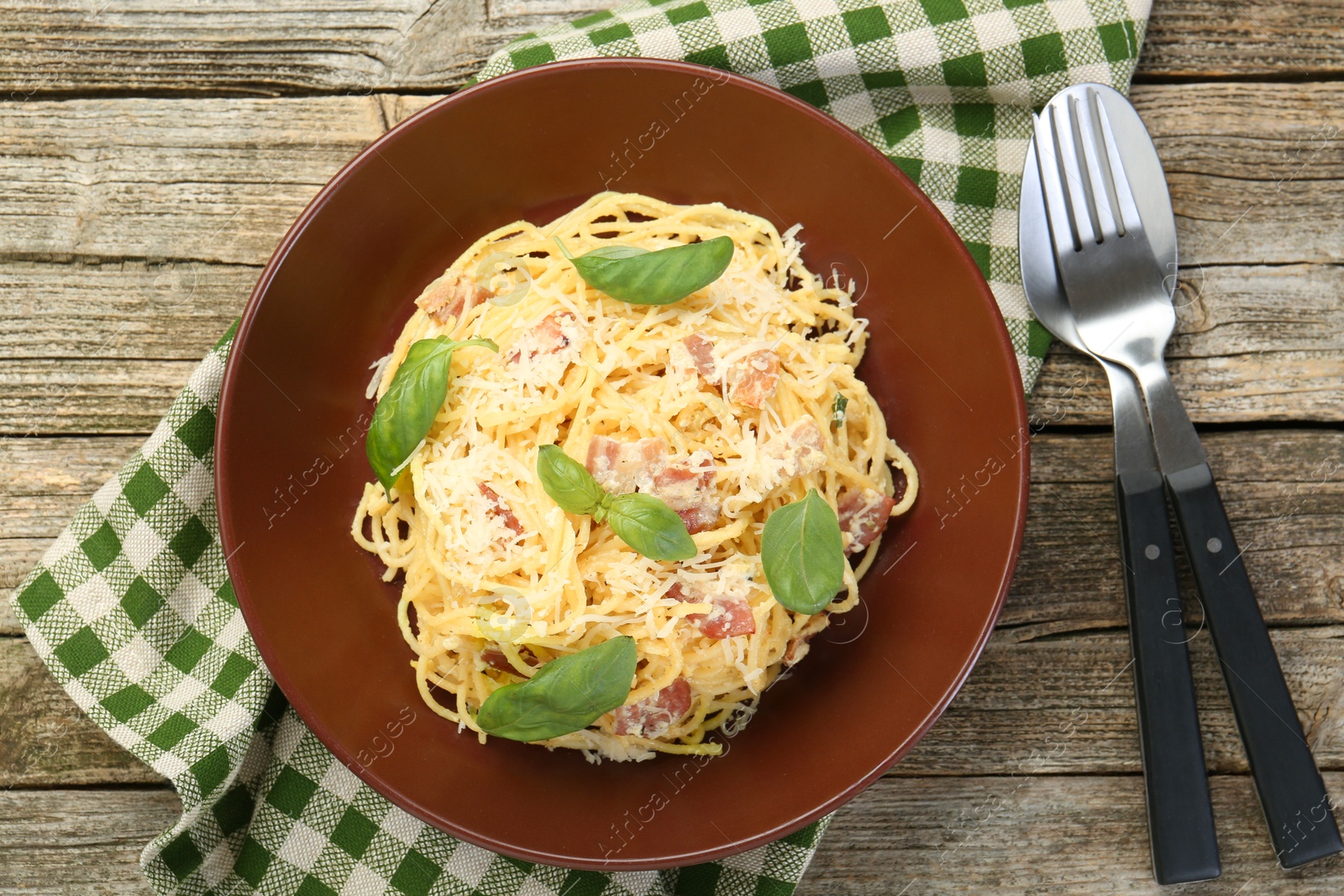 Photo of Delicious pasta Carbonara served on wooden table, flat lay