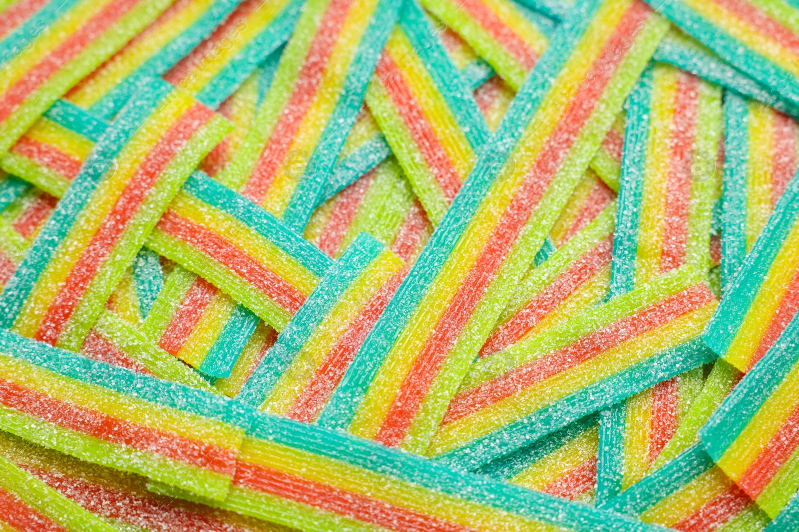 Photo of Tasty rainbow sour belts as background, closeup