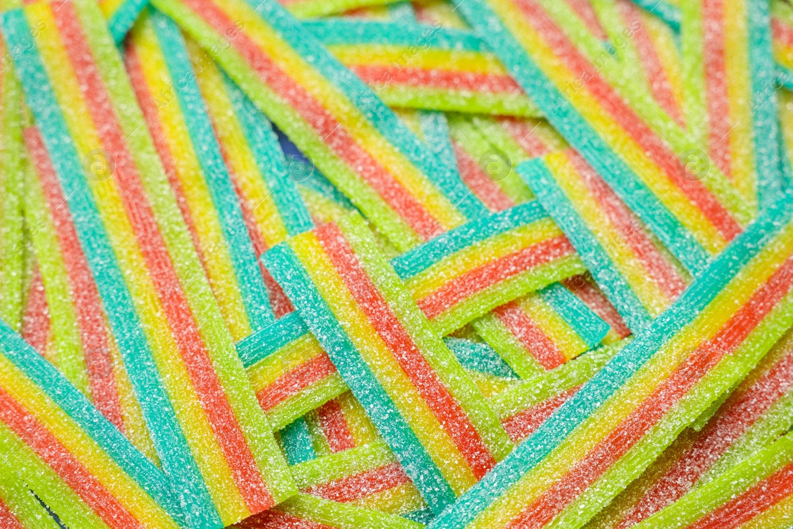 Photo of Tasty rainbow sour belts as background, closeup