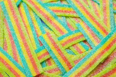 Photo of Tasty rainbow sour belts as background, closeup