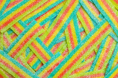 Photo of Tasty rainbow sour belts as background, top view