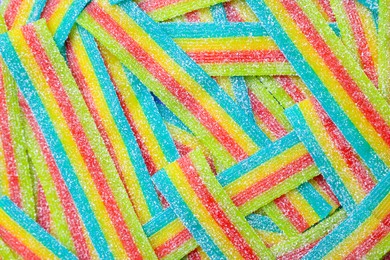 Photo of Tasty rainbow sour belts as background, top view