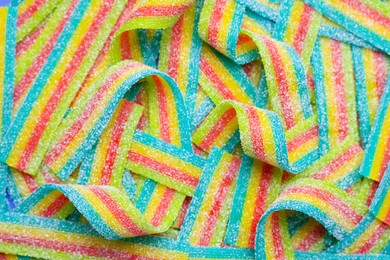 Photo of Tasty rainbow sour belts as background, top view